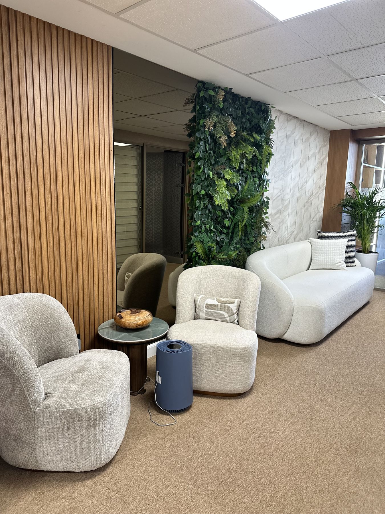 Agence Swisse Travel : mur végétal et fauteuils en bouclette